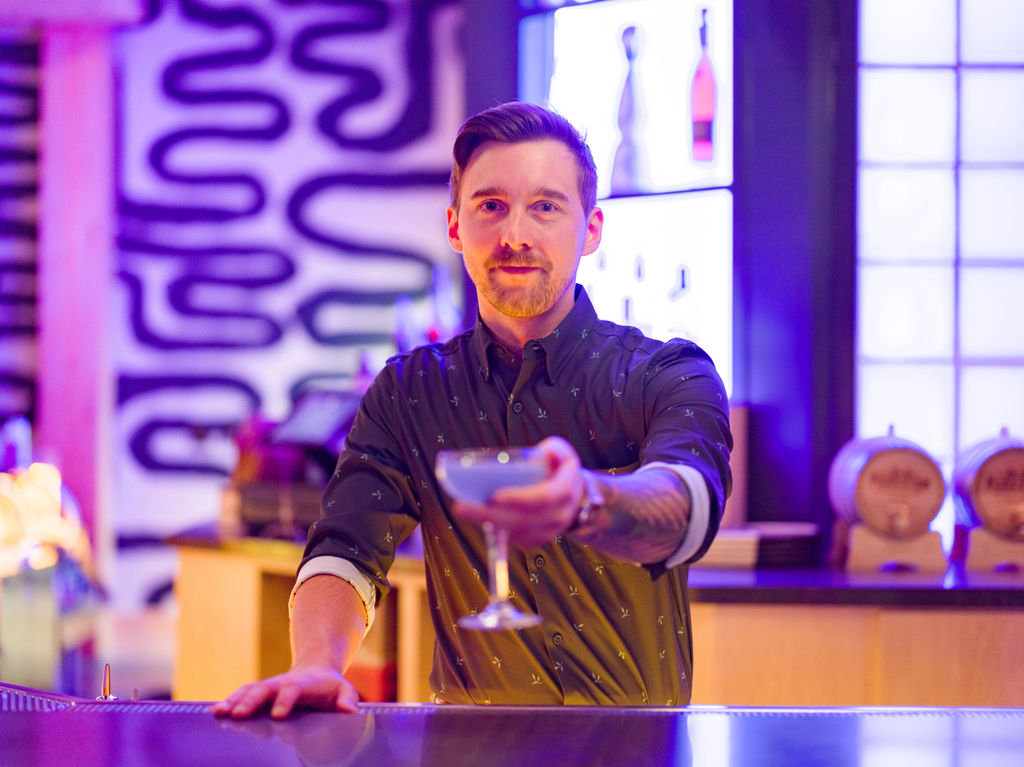 Bartender holding out cocktail